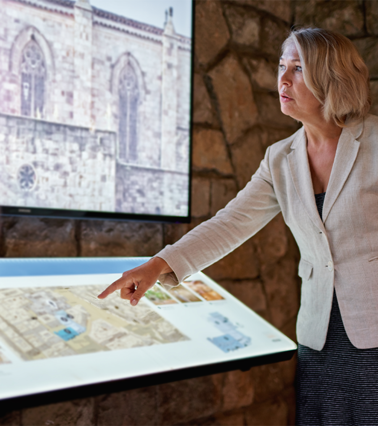 Woman touching interactive display in a museum.