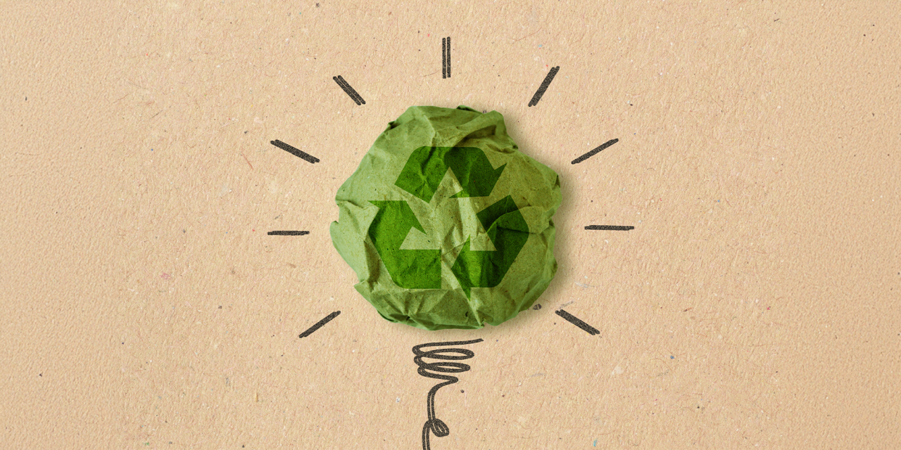 Paper recycling icon around a lightbulb idea.